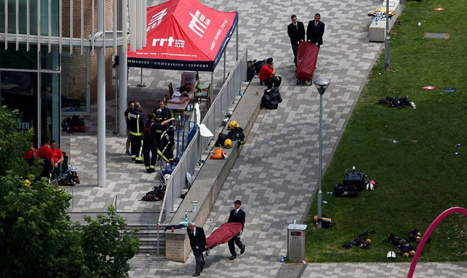 Lính cứu hỏa khiêng thi thể nạn nhân ra khỏi tòa chung cư. Ảnh: Daily Mail.