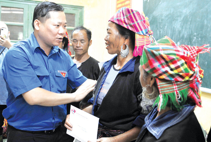 Bí thư T.Ư Đoàn, Chủ tịch T.Ư Hội LHTN Việt Nam Nguyễn Phi Long tặng quà đồng bào bị lũ lụt ở Mù Cang Chải. Ảnh: Xuân Tùng.