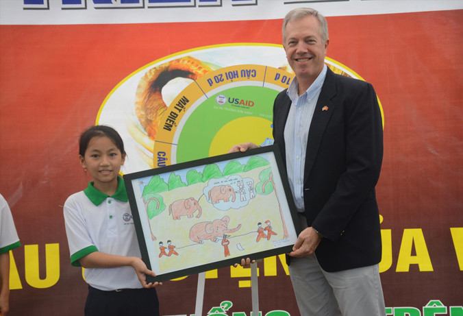 Học sinh huyện Nông Sơn tặng bức ảnh về voi cho Đại sứ Mỹ Ted Osius tại buổi lễ.