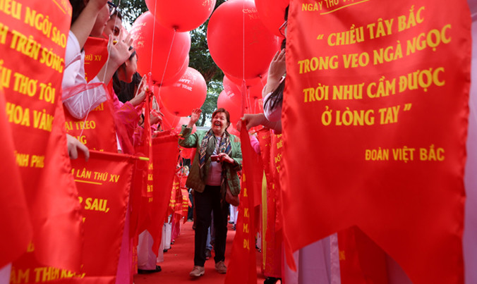 Một du khách nước ngoài thích thú với những câu thơ sắp được thả lên trời. Ảnh: Như Ý.