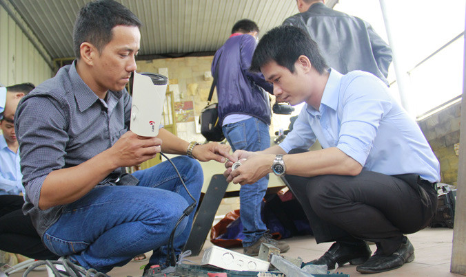 Anh Trần Hữu Đức Nhật, thành viên nhóm “Phát triển Đà Nẵng” (bên trái) cùng đơn vị tài trợ lắp camera tại nút giao Nguyễn Văn Linh - Nguyễn Tri Phương. Ảnh: Thanh Trần.