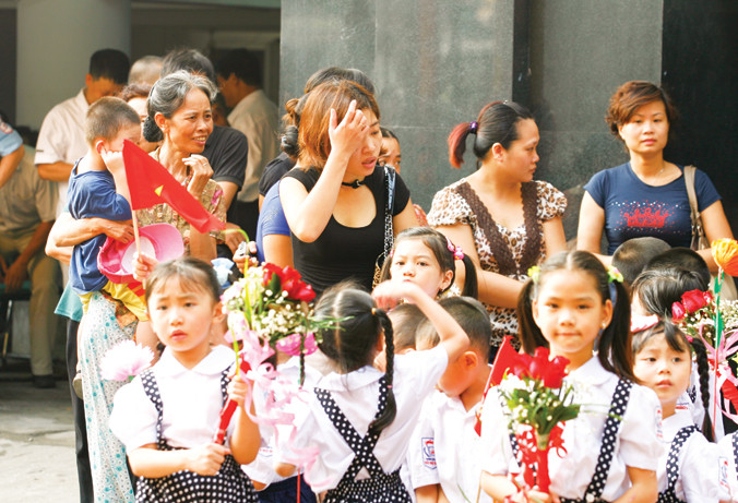 Ngày tựu trường, phụ huynh lại lo các loại phí học cho con. Ảnh: Hồng Vĩnh.