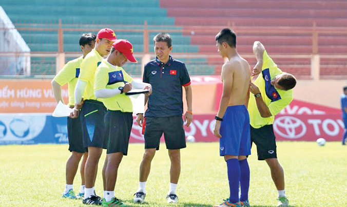 HLV Hoàng Anh Tuấn (giữa) cùng các cộng sự kiểm tra các chỉ số sinh học và thể lực của các cầu thủ. Ảnh: VSI. 