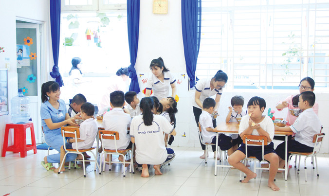 Giáo viên đặc biệt cho trẻ ăn trưa​. Ảnh: Ngô Tùng.