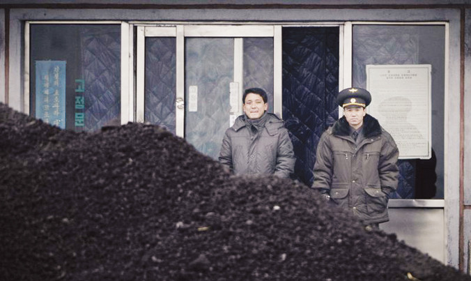 Hai người Triều Tiên đứng cạnh đống than bên bờ Áp Lục - con sông hình thành biên giới tự nhiên giữa Trung Quốc và Triều Tiên. Ảnh: Getty Images.