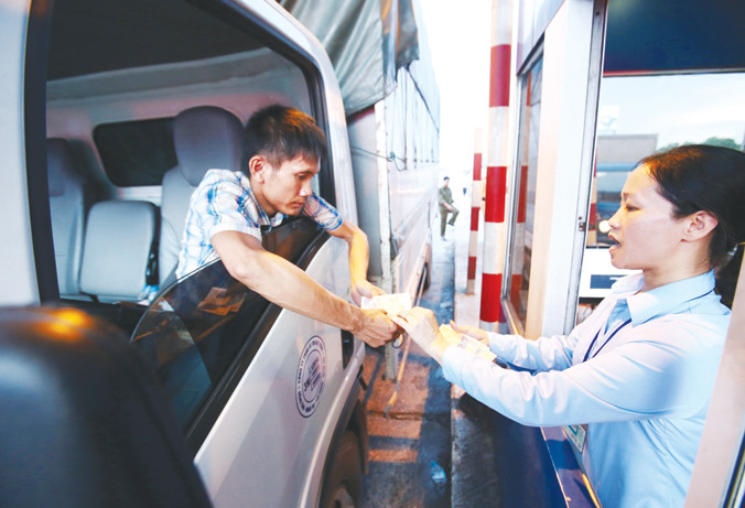 Lái xe đưa tiền lẻ tại trạm thu phí Quốc lộ 5 để phản đối thu phí cao. Ảnh: Như Ý.