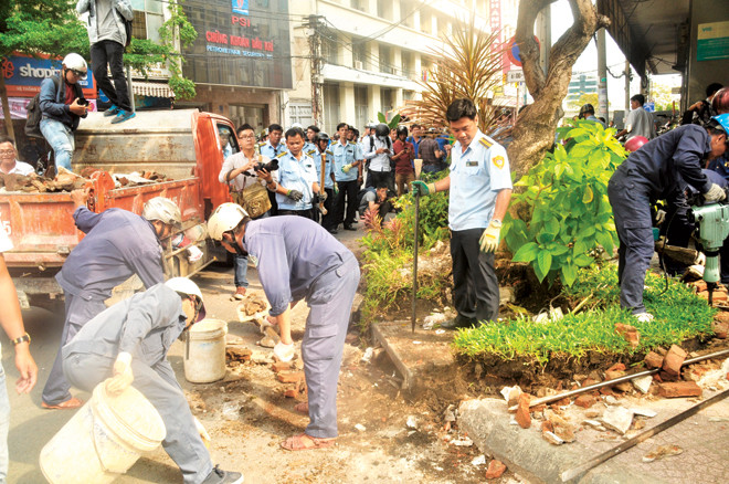 Đoàn kiểm tra, xử lý của quận 1 tháo dỡ nhiều công trình lấn chiếm vỉa hè trong thời gian qua. Ảnh: Văn Minh.
