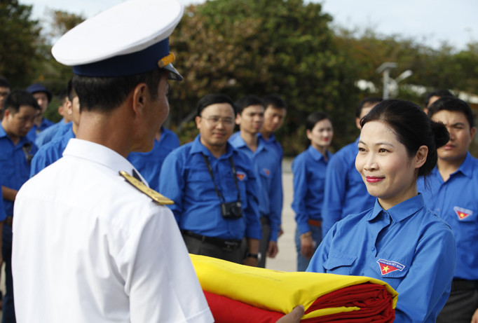 Chị Nguyễn Thị Quý Phương, nguyên Bí thư Đoàn Khối các cơ quan T.Ư trao lá cờ số 192 của Đồn Biên phòng Lũng Cú (Hà Giang) gửi tặng cán bộ, chiến sĩ Trường Sa. Ảnh: Bình Minh.