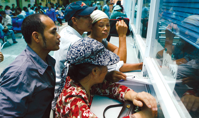 Người nhà bệnh nhân đăng ký khám bệnh bảo hiểm y tế ở viện K Trung ương. Ảnh: Hồng Vĩnh.