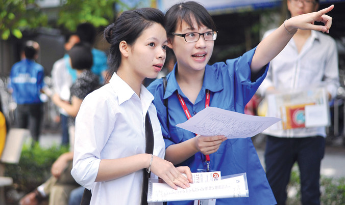 Sinh viên tình nguyện hướng dẫn cho thí sinh dự thi THPT Quốc gia. Ảnh: Xuân Tùng.