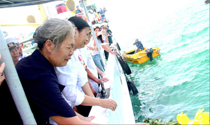 Bà Doãn Thị Mai và chị Doãn Thị Thu xúc động trong lễ thả hoa tưởng niệm các liệt sĩ tàu C235 trên biển.