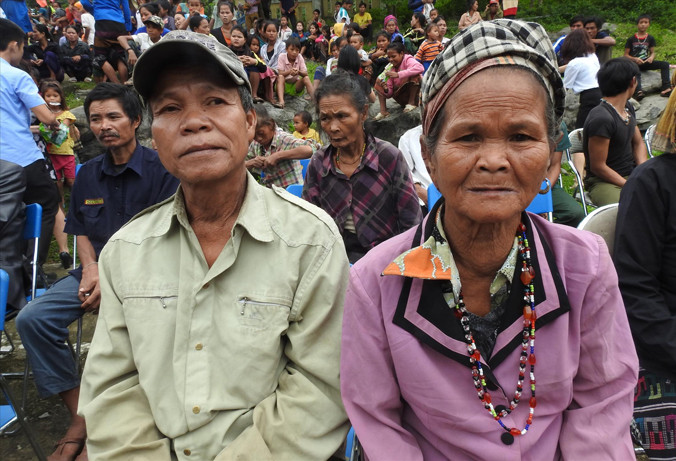 Ông Đinh Nê và bà Y Rú trong một lần tập trung ngồi chờ đến lượt nhận quà cứu trợ.