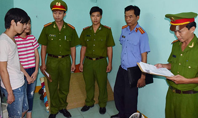 Cơ quan Công an đọc lệnh bắt, khám xét 2 đối tượng hack nick Facebook để lừa đảo tại Huế tháng 6/2016. Ảnh: cand.com.vn.