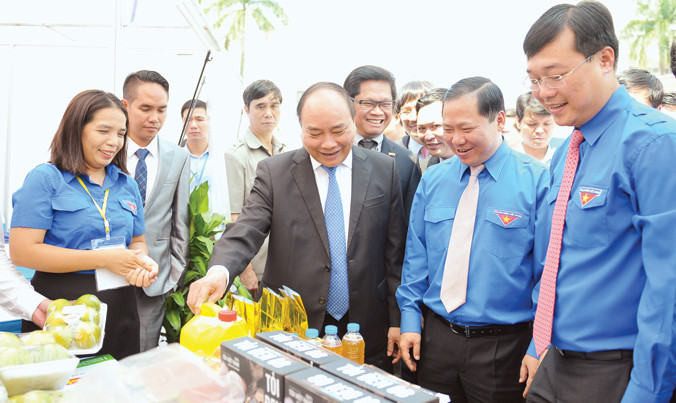 Thủ tướng Nguyễn Xuân Phúc và Bí thư thứ nhất T.Ư Ðoàn Lê Quốc Phong cùng các đại biểu tham quan các gian hàng trong Lễ phát động chương trình thanh niên khởi nghiệp năm 2016. Ảnh: Xuân Tùng.