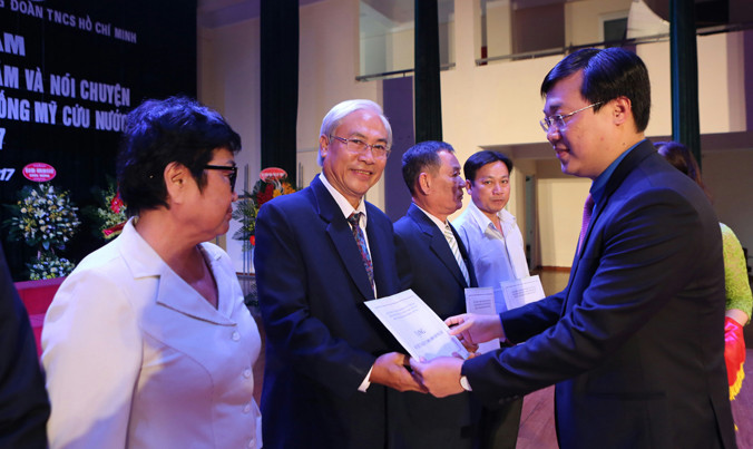 Anh Lê Quốc Phong trao sổ tiết kiệm cho các cựu TNXP. Ảnh: Như Ý.