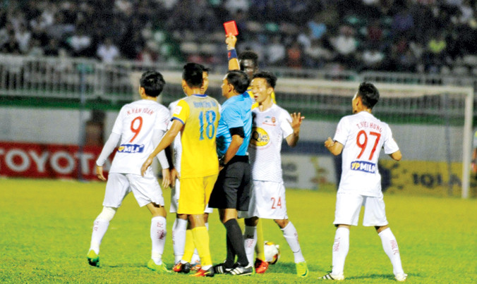 Trọng tài Xuân Nguyện rút thẻ đỏ truất quyền thi đấu với A Hoàng sau khi cầu thủ này cố tình đưa bóng vào cuộc khi chưa có hiệu lệnh của trọng tài. Ảnh: VSI.