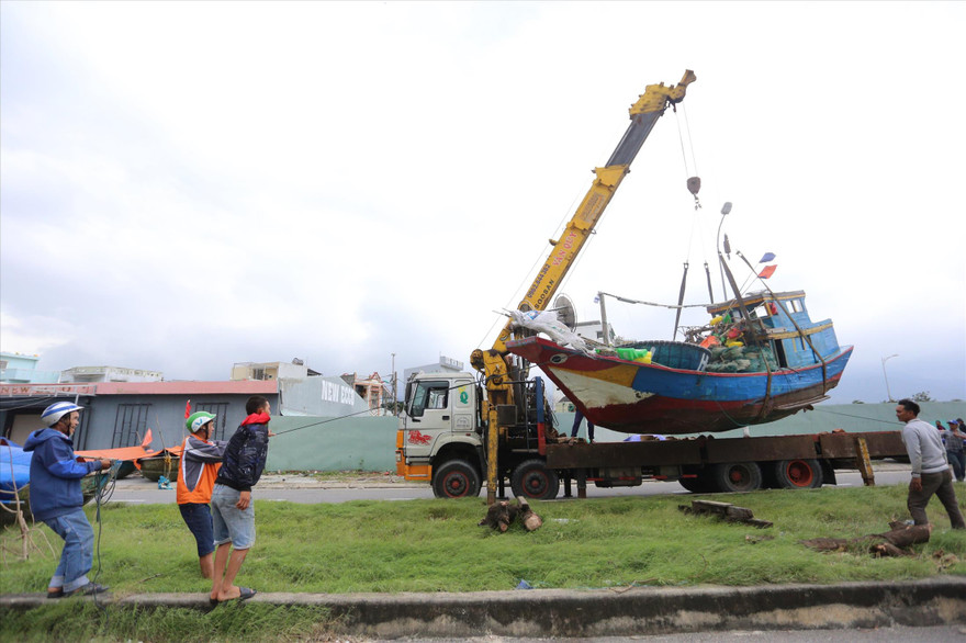 Các chủ tàu đánh cá cẩu tàu thuyền đi trú bão. Ảnh: Giang thanh 