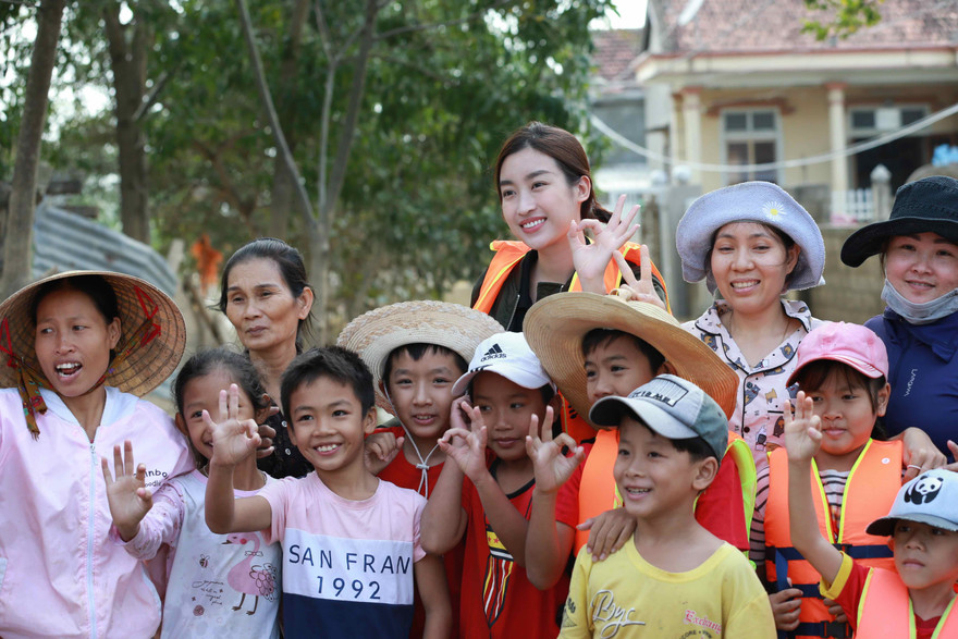Hoa hậu Đỗ Mỹ Linh trao quà và chụp hình cùng bà con vùng lũ Ảnh: Minh Đức 