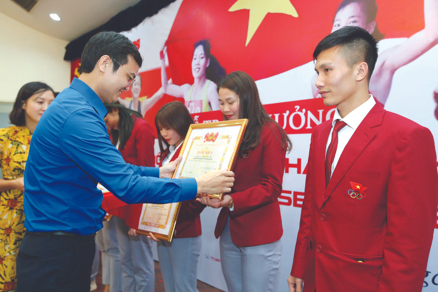 Anh Bùi Quang Huy, Bí thư T.Ư Đoàn TNCS Hồ Chí Minh trao bằng khen cho các VĐV điền kinh giành HCV tại SEA Games 30. Ảnh: MẠNH THẮNG