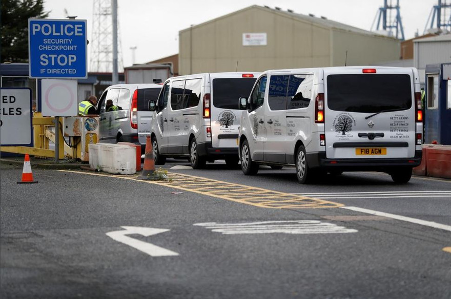 Xe phục vụ tang lễ xuất hiện tại khu vực phát hiện các thi thể Ảnh: Reuters