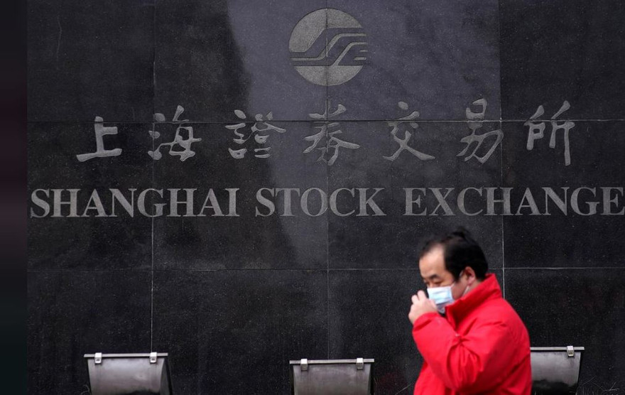 Một người đàn ông đeo khẩu trang đi ngang qua Sở giao dịch chứng khoán Thượng Hải ngày 3/2. Ảnh: Getty