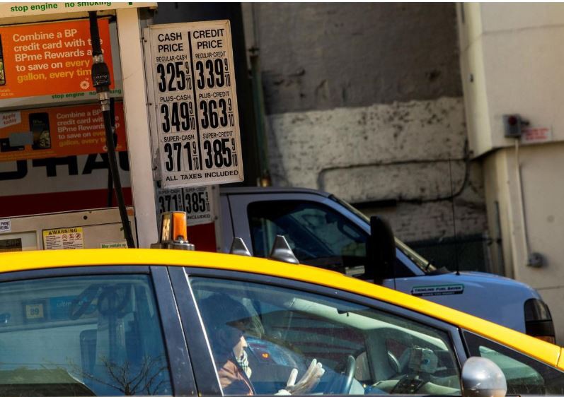  Một tài xế taxi đeo găng tay cao su vào đổ xăng trong khi giá xăng đã giảm do Covid-19 tại New York, Mỹ, ngày 14/3. Ảnh: Getty 