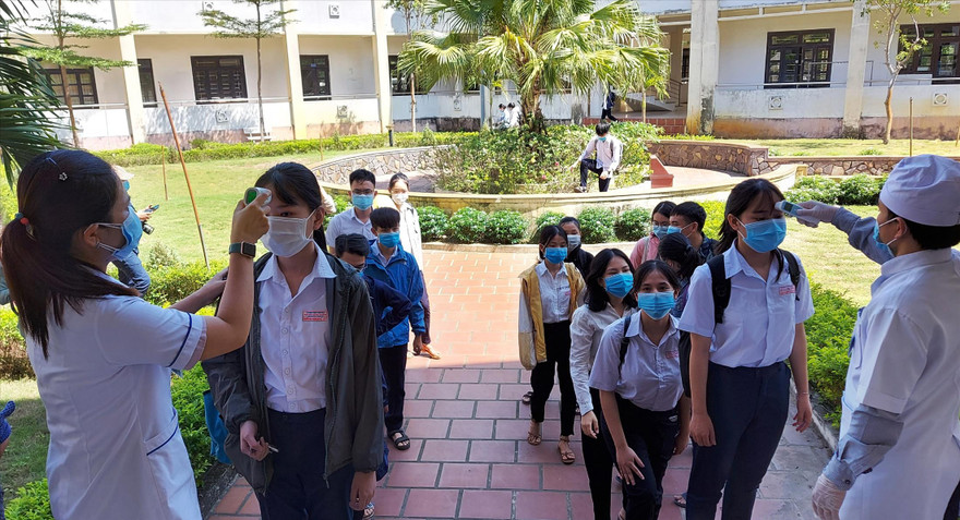 Thí sinh dự thi sẽ xếp hàng đo thân nhiệt trước khi vào phòng làm thủ tục thi. Ảnh: Như Ý