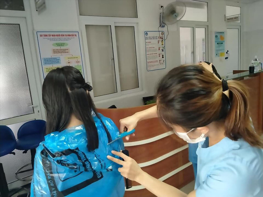 Cắt bỏ mái tóc dài để làm nhiệm vụ chống COVID-19 tại Bệnh viện Đà Nẵng. Ảnh: T.H 