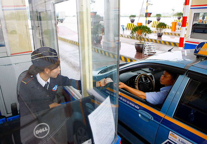 Khách hàng trả tiền tại trạm thu phí BOT Pháp Vân Cầu Giẽ. ẢNH: MINH CHÂU