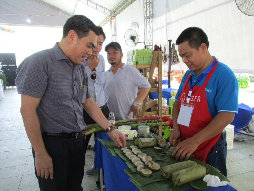 Người dân thích thú dùng thử sản phẩm bánh chưng, bánh tét nhân cá basa