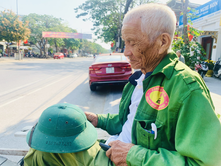 Ông Năm “xích lô” ghi số điện thoại của mình lên chiếc mũ cối để khỏi quên