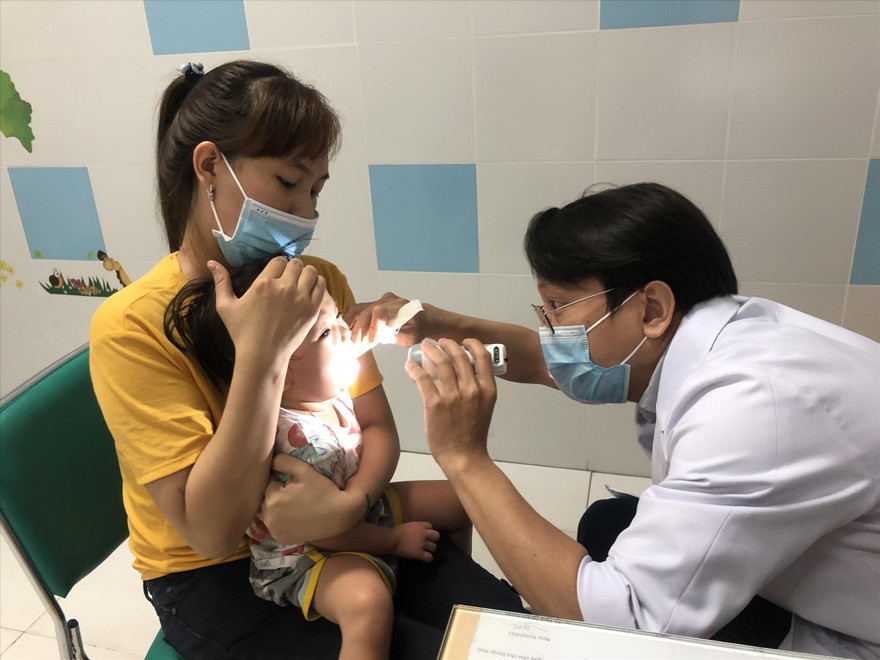 BS Nguyễn Đình Qui khám bệnh cho bệnh nhi sáng 19/3. Ảnh: U.P