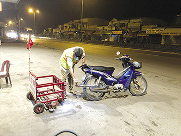 Anh Đinh Minh Cảnh và chiếc xe hút đinh trên đường phố vào lúc sáng sớm 