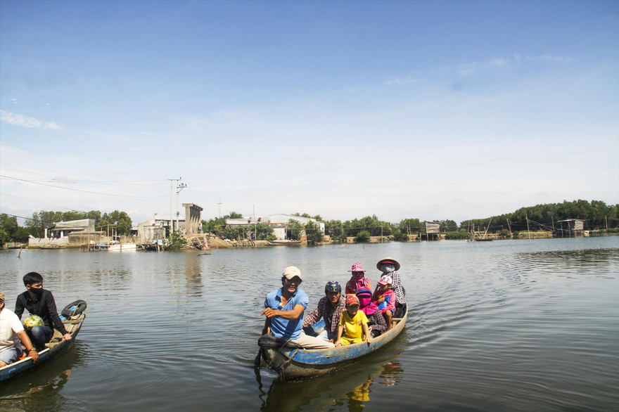 Người dân phải chèo đò sang sông. Ảnh: Tr.Định