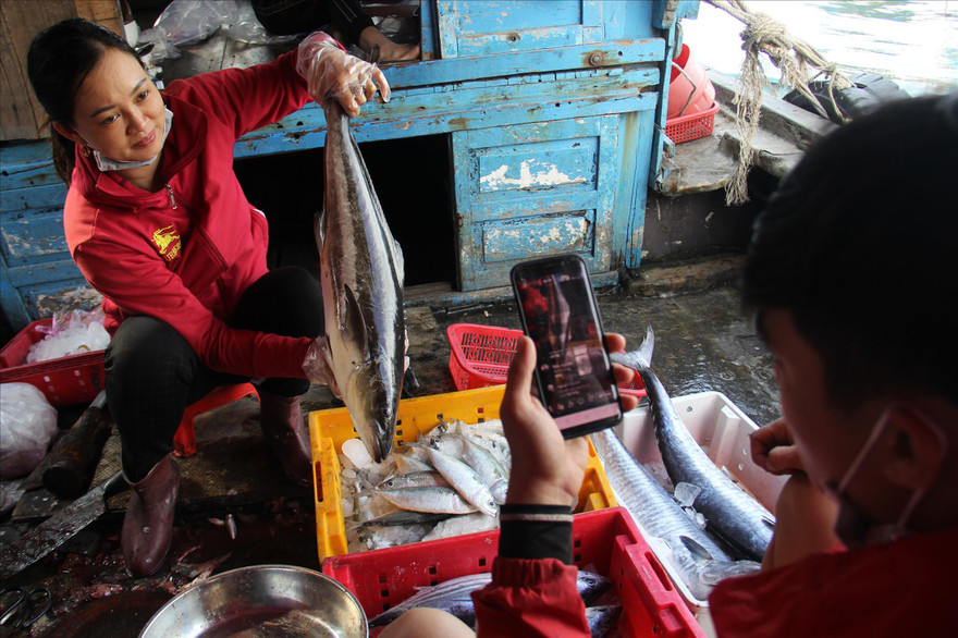 Hai mẹ con bà Lan livestream bán hải sản ngay sau khi tàu vào bờ. Ảnh: Thanh Trần
