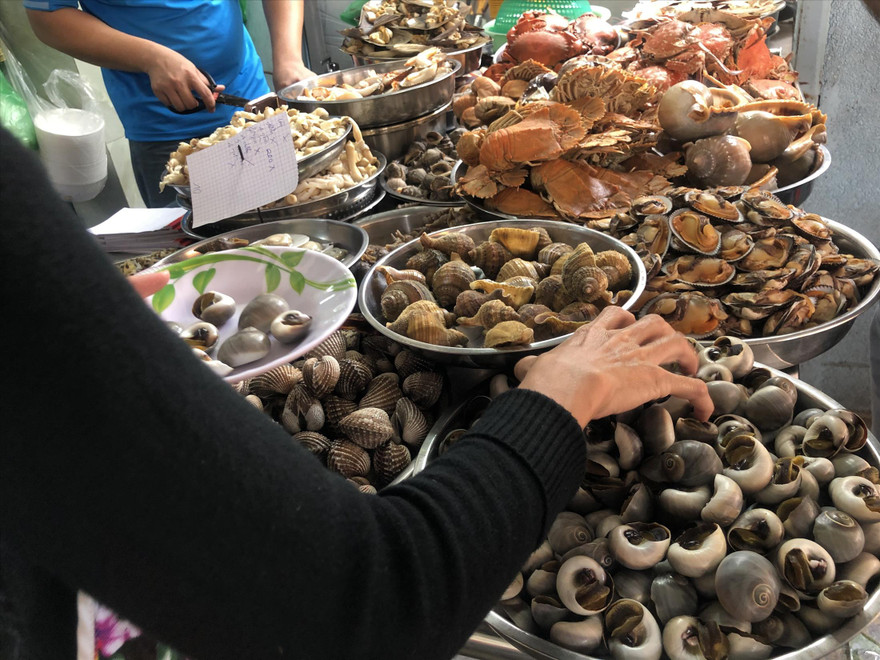 Nhân viên dùng tay không bốc ốc và chế biến cho khách ẢNH: U.P