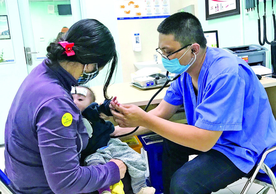 Bác sĩ Hùng khám cho bệnh nhi. Ảnh: Thái Hà 