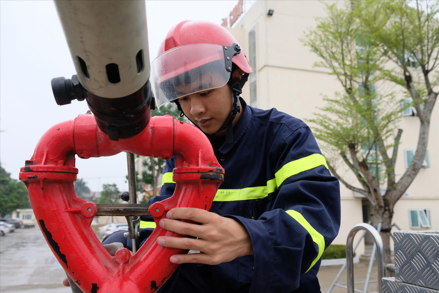 Hạ sĩ Tống Văn Đông bảo dưỡng thiết bị chữa cháy. Ảnh: PV