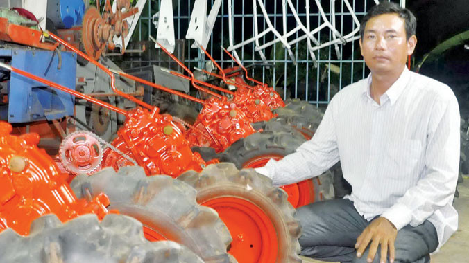 Ông Liêm bên cạnh những chiếc máy đã làm xong nhưng chưa giao.