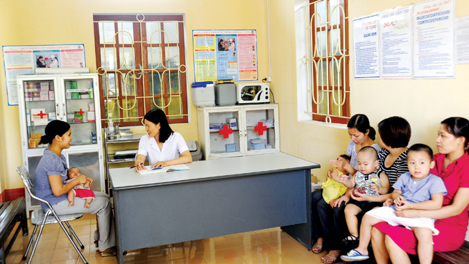 Cán bộ y tế tư vấn trước tiêm chủng cho bà mẹ.