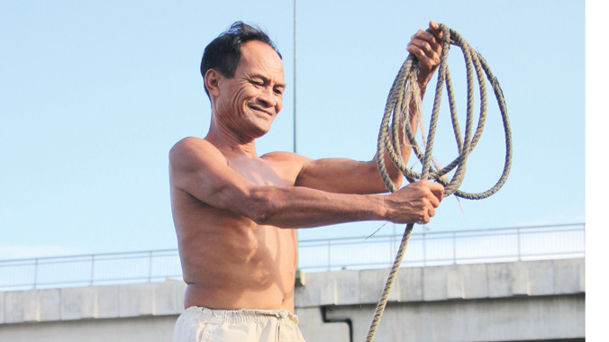 Ông Ba Chúc với cuộn dây dài dùng để cứu người.