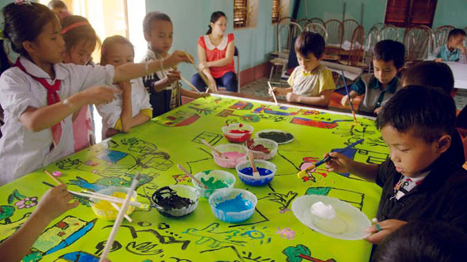 Các em nhỏ hăng say vẽ tranh tập thể.