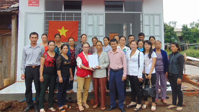 Bà Đỗ Thị Bảy (đứng giữa hàng đầu) bên nhà mới.