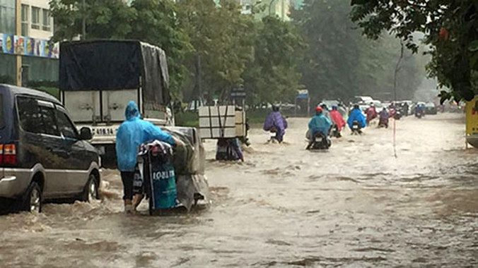 Mưa lớn ngày 25/11 làm ngập hơn nửa bánh xe trên phố Hoàng Minh Giám.