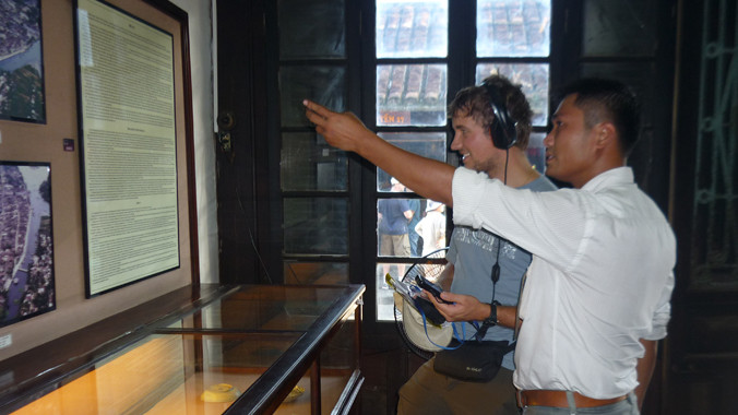 Du khách dùng thiết bị audio guides.