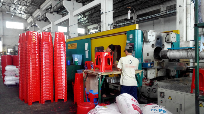 Trực cắt gọt ghế nhựa vừa mới ra lò còn nóng hổi. Ảnh: Việt Văn