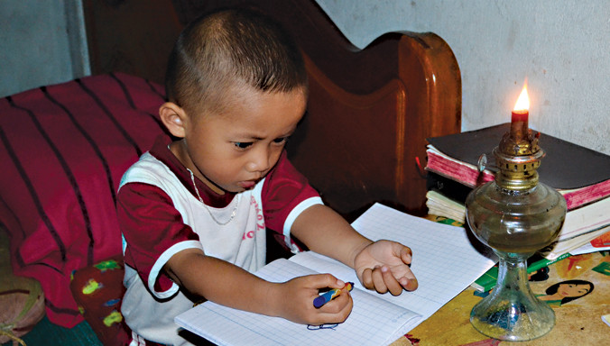 Trẻ con ở buôn Ea Su học dưới ánh đèn dầu.