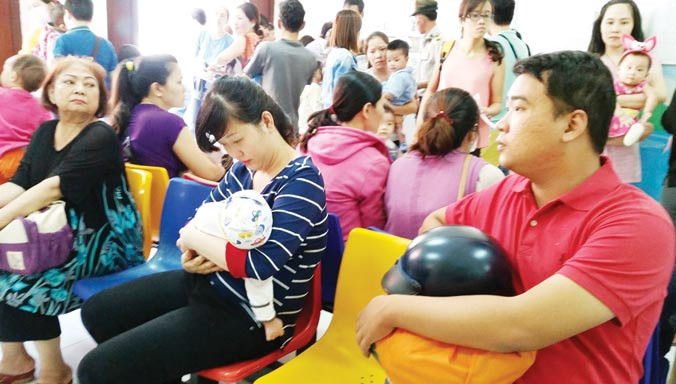 Những người may mắn đăng ký thành công qua tổng đài 1080 để có được 1suất tiêm vắc-xin dịch vụ Pentaxim tại Bệnh viện Nhi đồng 2 TPHCM vào sáng 30/12. Ảnh: Quốc Ngọc