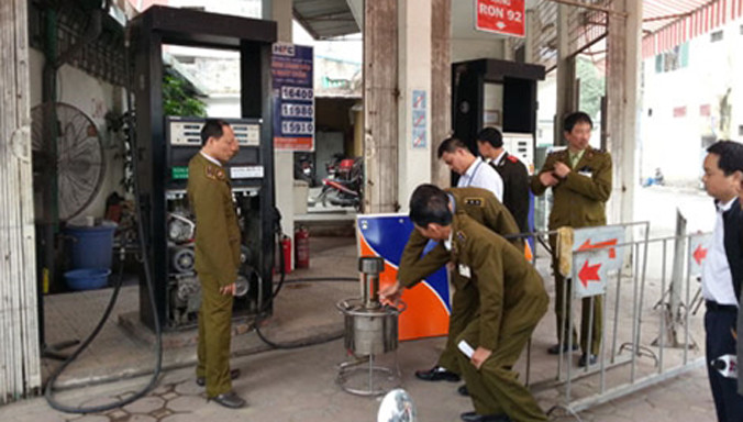 Lực lượng chức năng kiểm tra cây xăng gian lận.