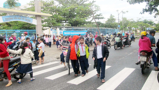 Giờ tan trường, học sinh tiểu học Võ Thị Sáu ùa ra đường, canh cánh nỗi lo tai nạn nếu bãi đỗ xe được xây dựng. Ảnh: N.C